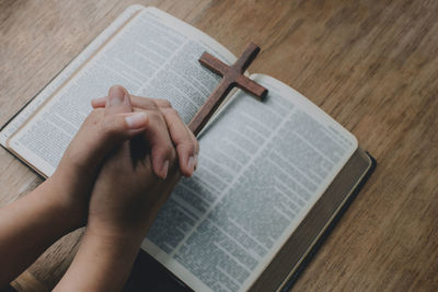 Midsection of person reading book on table