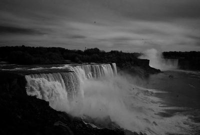 Scenic view of waterfall against sky