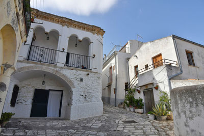 A narrow street between the old houses of grottole, a village in the basilicata region, italy.