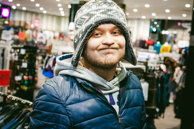 Close-up portrait of man wearing knit hat while standing in clothing store