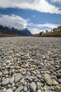 Surface level of stones on shore against sky