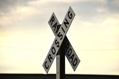 Low angle view of information sign against sky