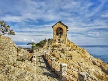 Chapel by sea against sky