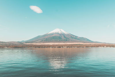 Scenic view of lake and mountains against blue sky