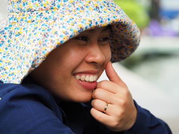 Close-up of cheerful young woman wearing hat