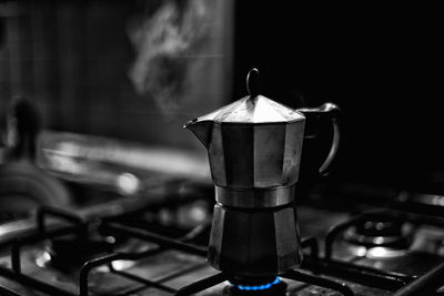 Close-up of espresso maker on burning stove in kitchen