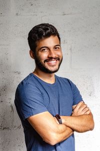 Portrait of young man standing against wall