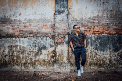 Man standing against wall in city