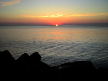 Scenic view of sea against romantic sky at sunset