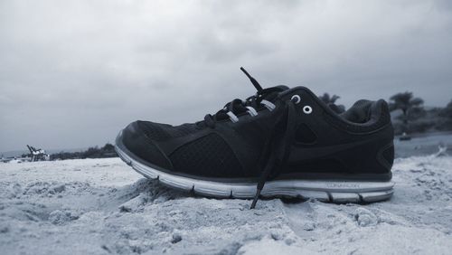 High angle view of shoes on snow covered field against sky