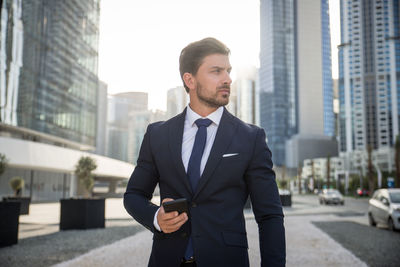 Businessman standing outdoors in city