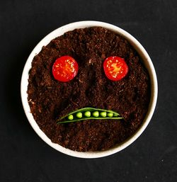 High angle view of smiley made up of sliced tomatoes and green pea