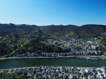 Scenic view of buildings and mountains against clear blue sky