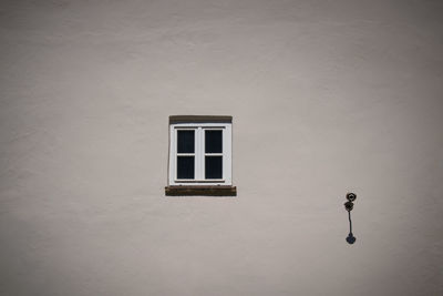 Low angle view of window on white wall of building