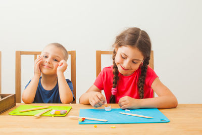 Portrait of a smiling girl sitting on table