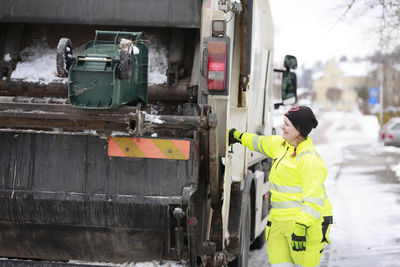Woman operating garbage truck