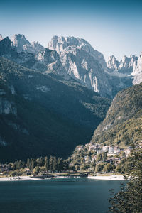 Scenic view of townscape by mountains against sky