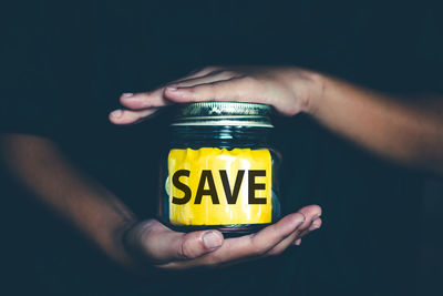 Close-up of person hand holding yellow text