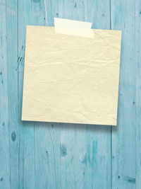 Close-up of adhesive note stuck on wooden wall