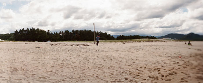 Scenic view of beach against cloudy sky