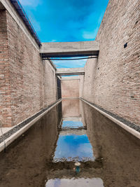 Canal amidst buildings against sky