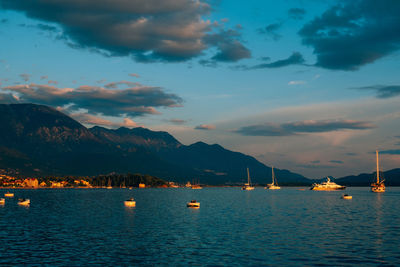 Sailboats in sea against sky during sunset