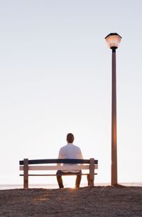Rear view of man sitting on bench
