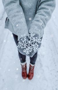 Low section of woman standing in snow