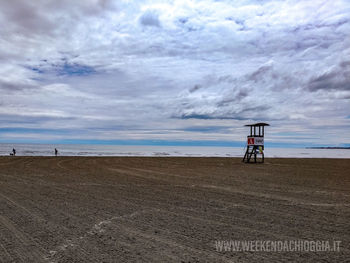 Lifeguard hut on beach against sky