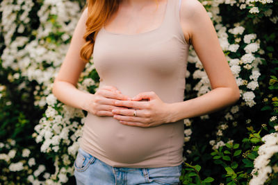 Midsection of woman standing by plants