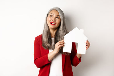 Portrait of a smiling young woman against white background