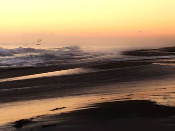 Scenic view of beach against sky during sunset