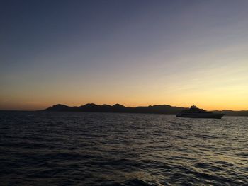 Silhouette of boat sailing in sea against clear sky