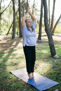 Full length of young woman exercising in park