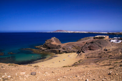 Scenic view of beach against clear blue sky