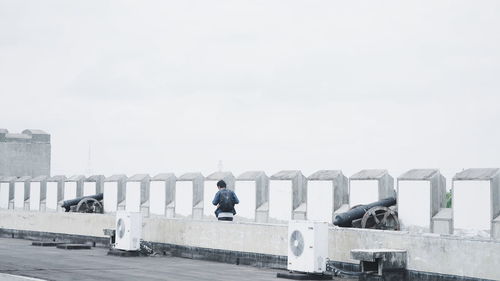 People on bridge against sky during winter