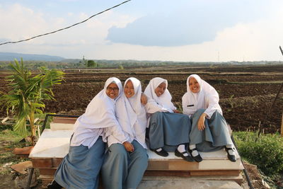 Rear view of people sitting on landscape