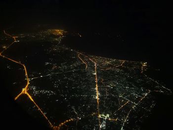 Low angle view of illuminated cityscape against sky at night