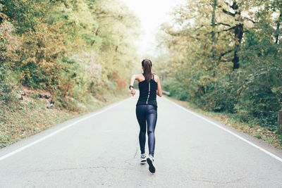 Rear view of woman walking in forest