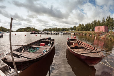 Panoramic view of boats moored in river against sky