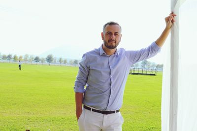 Portrait of young man standing on field