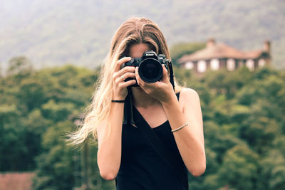 Portrait of woman holding camera