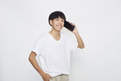 Portrait of smiling man standing against white background