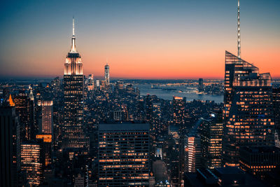 High angle view of illuminated empire state building and cityscape against clear sky at night