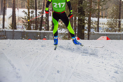 Low section of person skiing on snow covered field