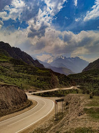 Road leading towards mountains against sky