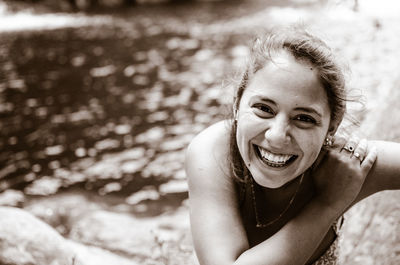 High angle portrait of smiling young woman against lake