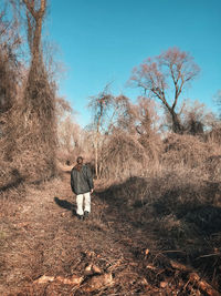 Rear view of man on field against sky