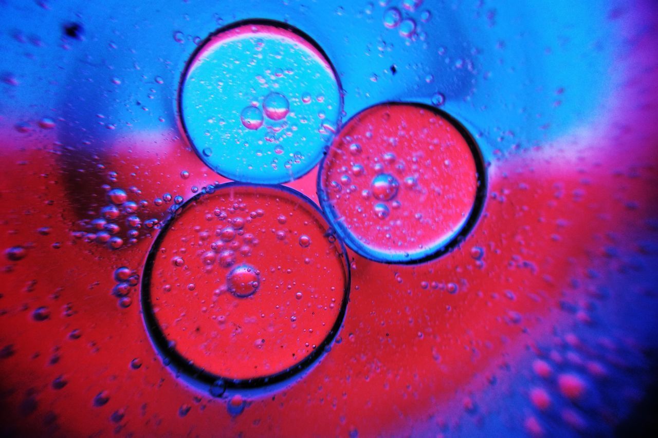 FULL FRAME SHOT OF WATER DROPS ON BLUE SURFACE