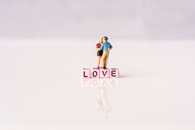 Woman standing by text on wall